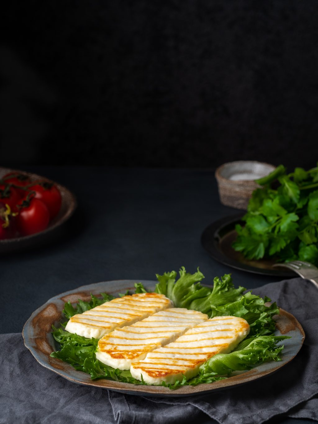 Grilled Halloumi, fried cheese with lettuce salad. Balanced diet on dark