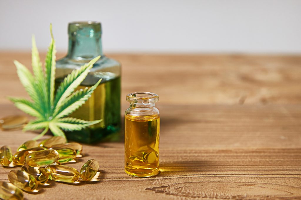 Medicinal cannabis with extract oil in a bottle on wooden background, Healthcare concept, Empty space for design.