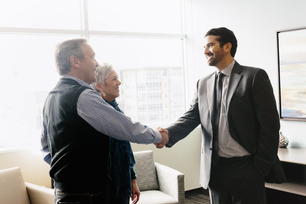 A man greeting a mature couple in an office. ,Salt Lake City,,USA