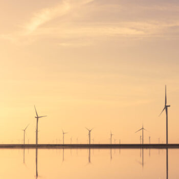 Tranquil minimalist landscape with rows offshore wind turbines