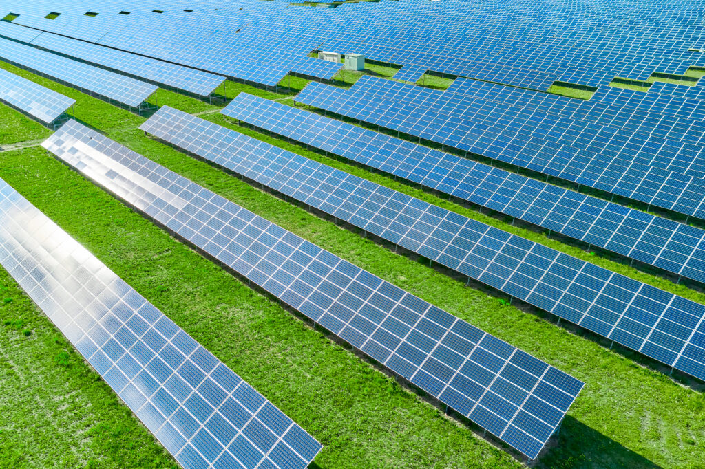 Solar panels producing green renewable energy. Solar power station in the field with green grass.