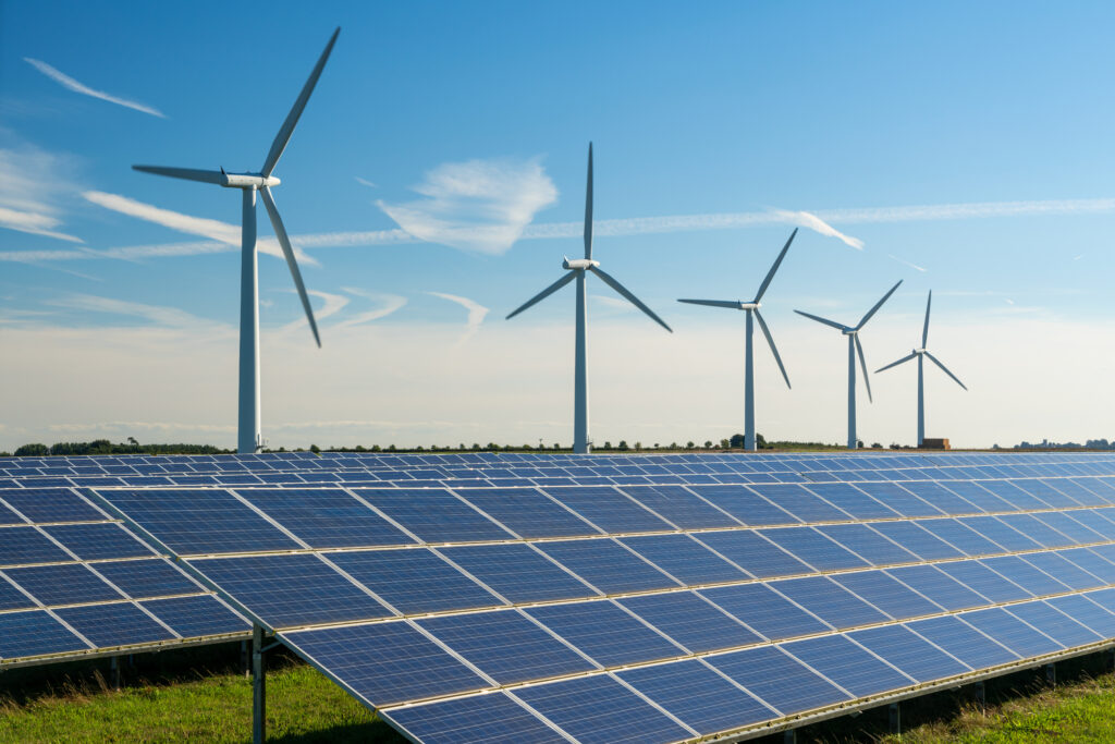 Sustainable energy ,United Kingdom,Wind turbine energy generaters on wind farm, with solar panels underneath.
